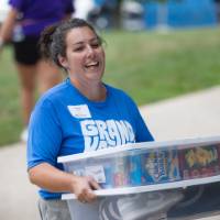 Woman smiling as she carries two clear totes
